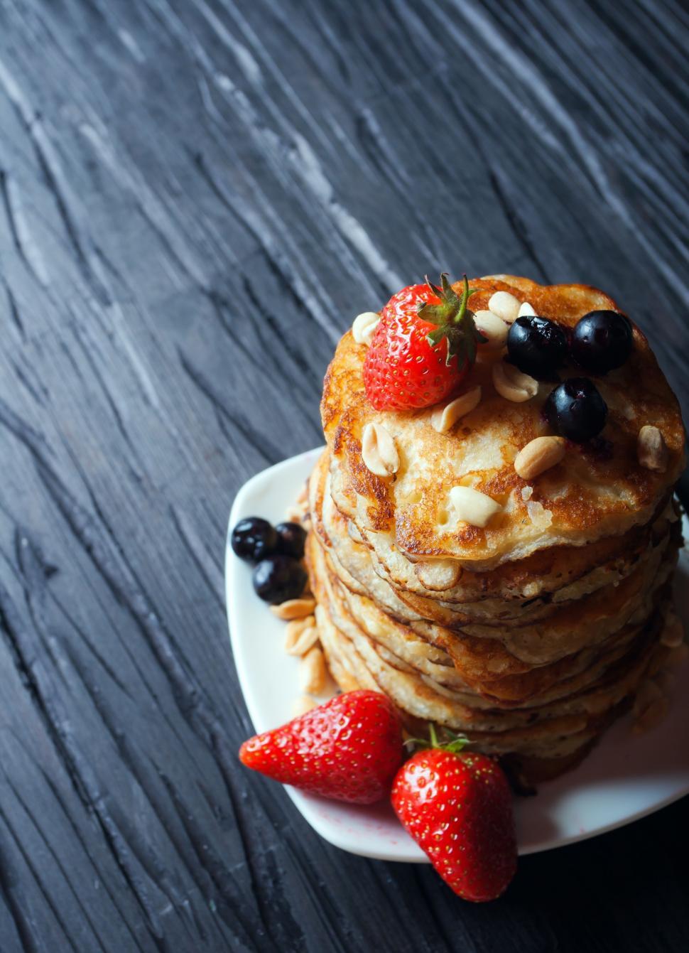 Free Image of Stack of Pancakes Topped With Berries and Nuts 