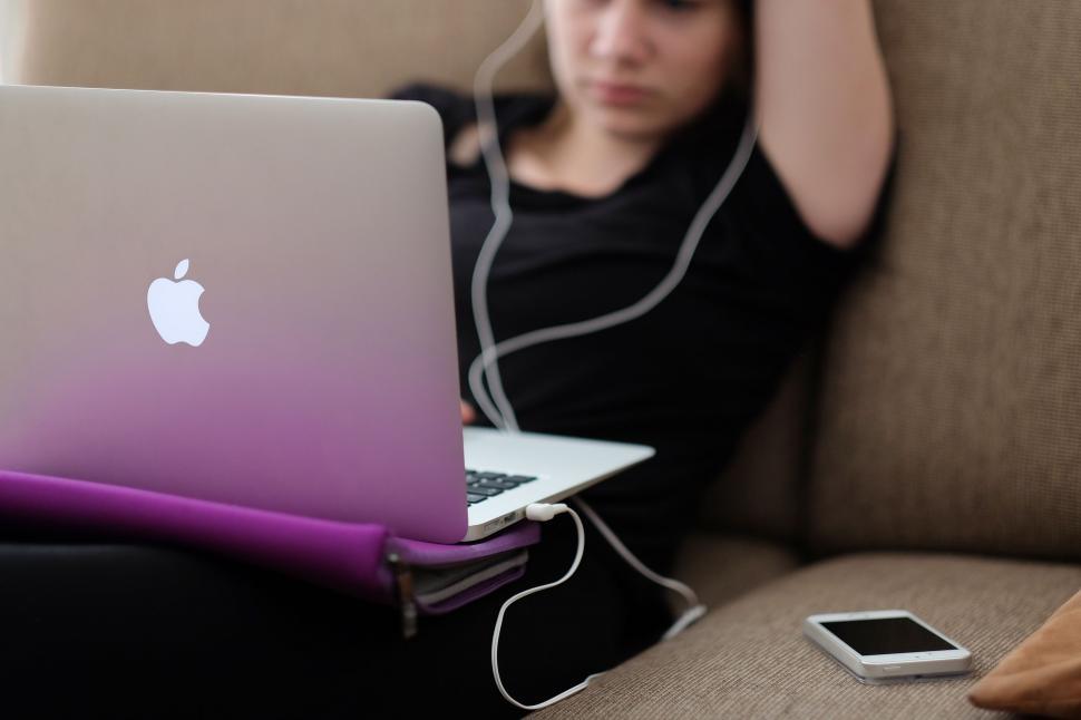 Free Image of Woman Sitting on Couch With Laptop and Headphones 