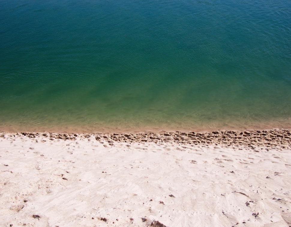 Free Image of Sandy Beach With Body of Water 