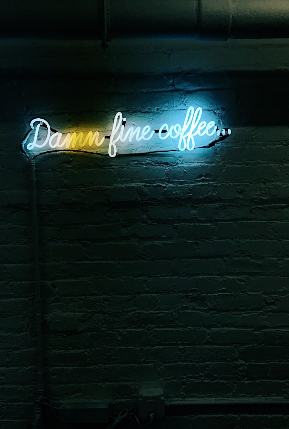 Free Image of Neon Sign Illuminating Brick Wall in Dark Room 