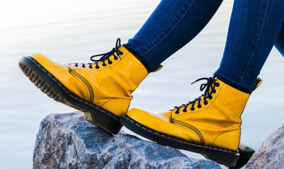 Free Image of Person in Yellow Boots Standing on a Rock 