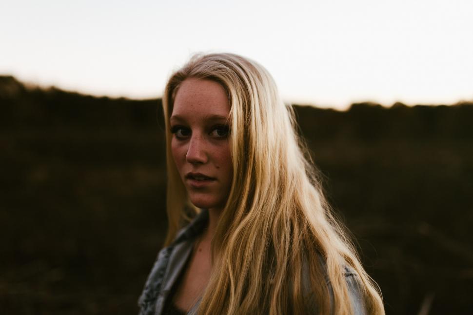 Free Image of Woman Standing in Field With Long Blonde Hair 