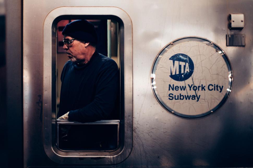 Free Image of Man Standing in Subway Car Looking Out the Window 