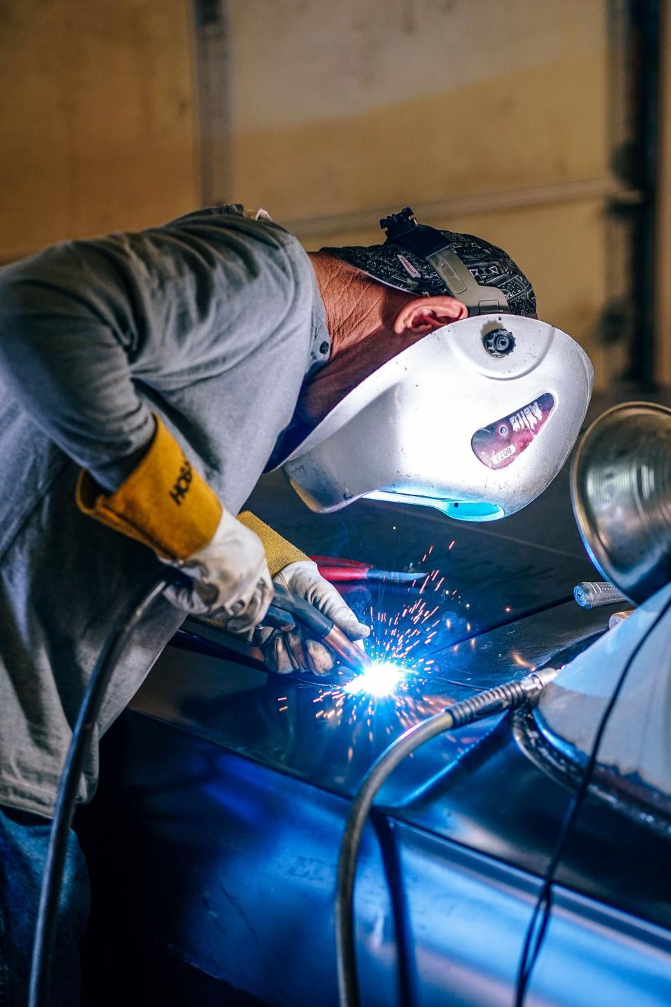 Free Image of Man Welding a Car in a Garage 