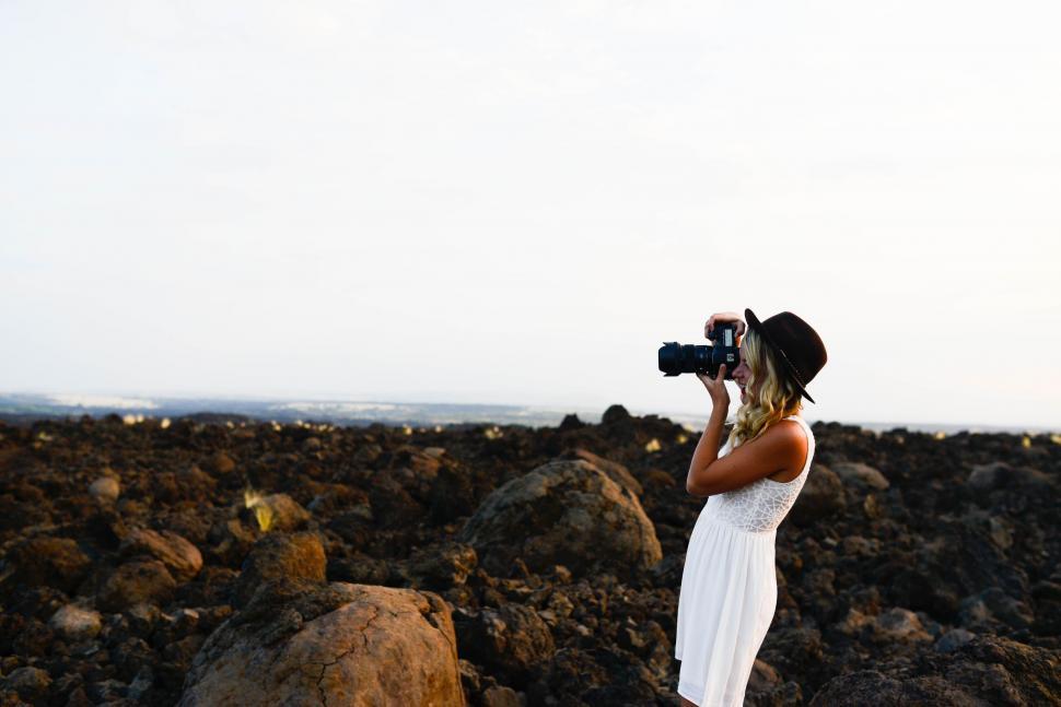 Free Image of Woman in White Dress Taking Picture 