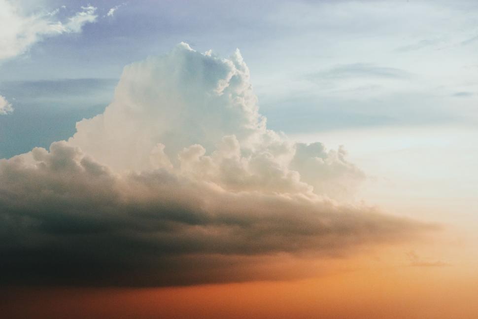 Free Image of Large Cloud Hovering Above Body of Water 