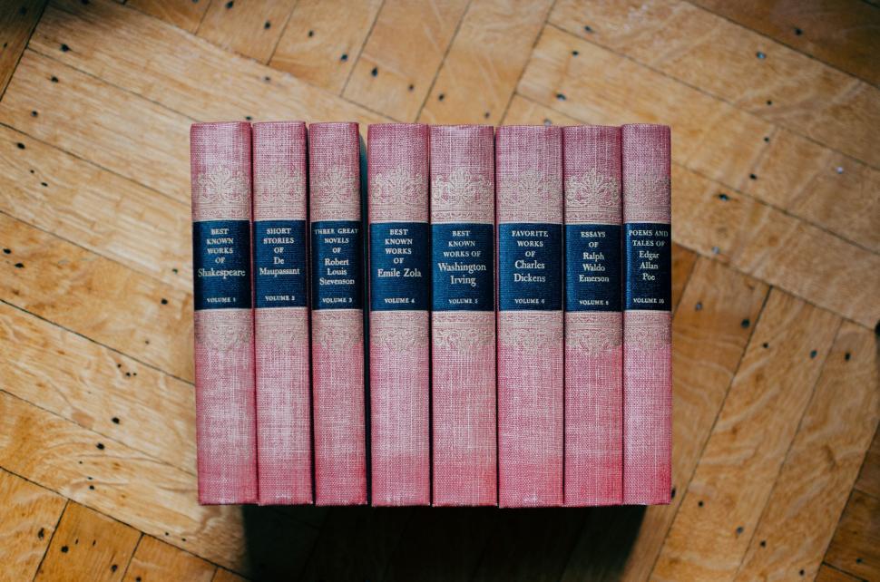Free Image of Stack of Pink Books on Wooden Floor 