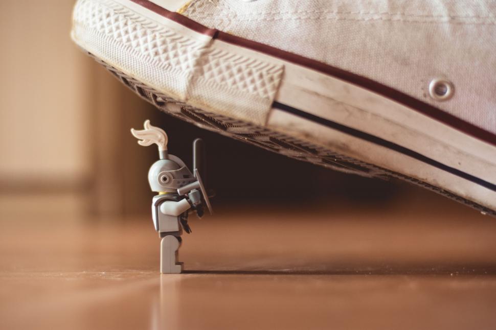 Free Image of Small Toy Standing Next to Pair of Shoes 