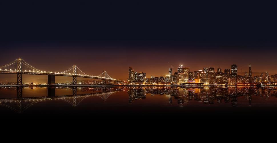 Free Image of City Skyline at Night With Bridge in Foreground 