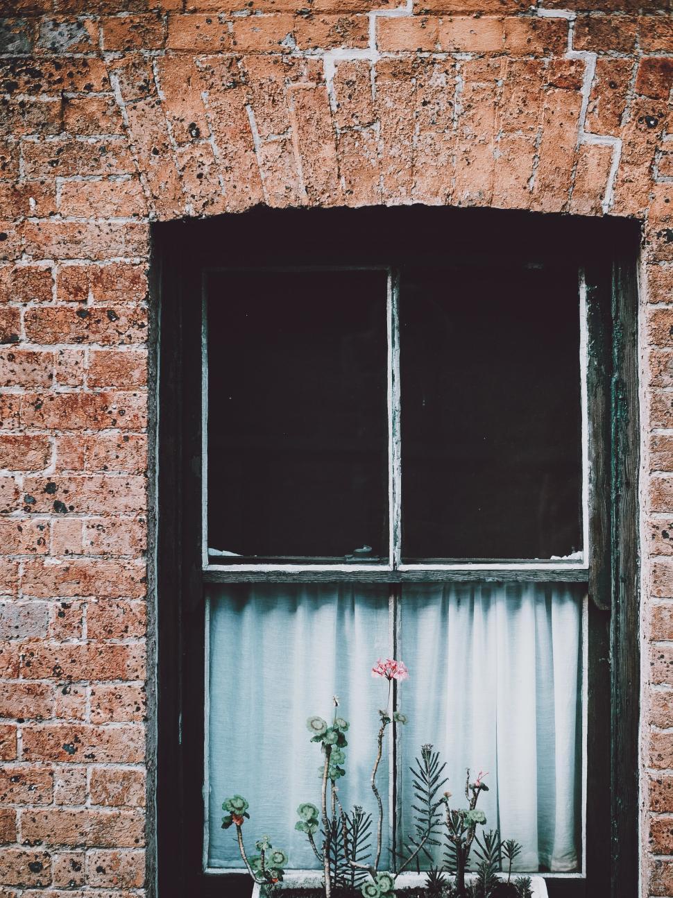 Free Image of A Brick Building With Window and Curtain 