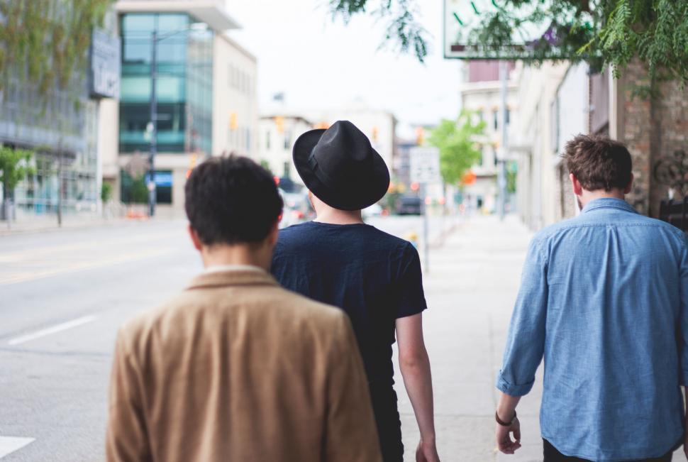 Free Image of Group of People Walking Down a Street Holding Hands 