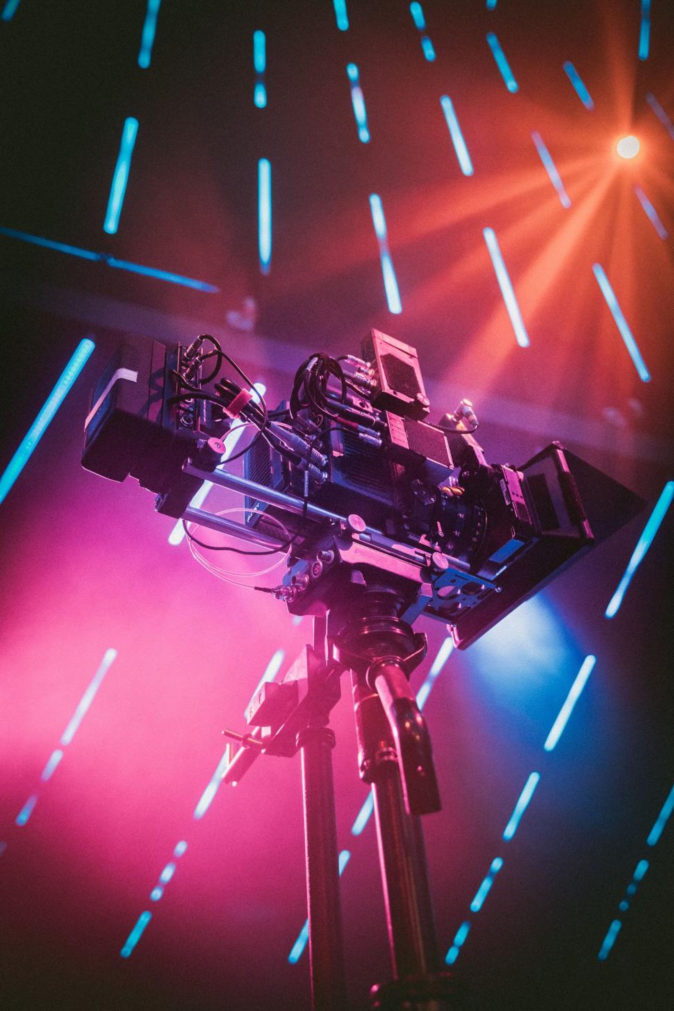 Free Image of Camera on Tripod in Front of Bright Lights 