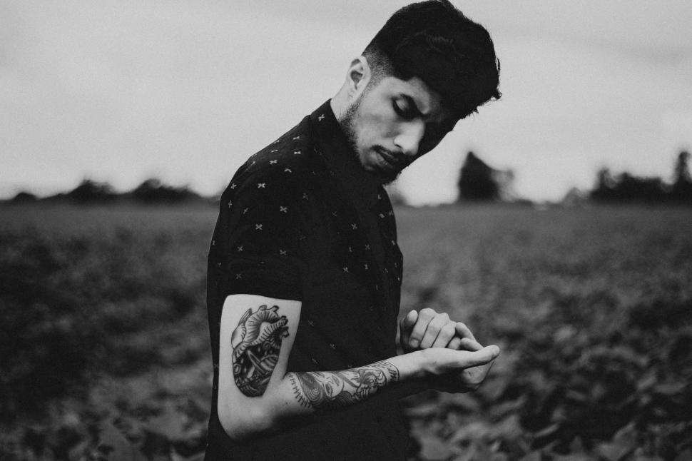 Free Image of Man Standing in Field With Arm Tattoo 