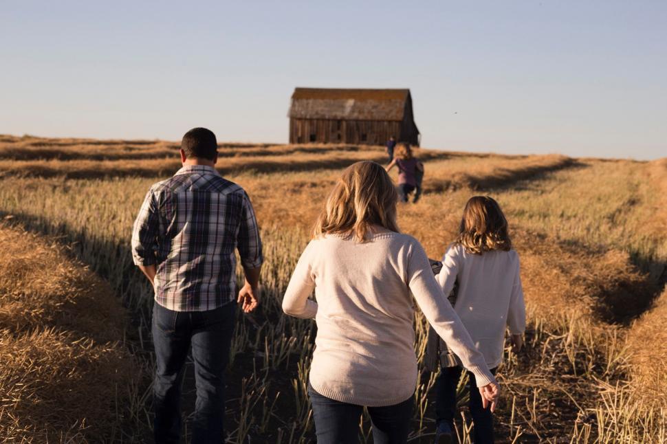 Free Image of Group of People Walking Through a Dry Grass Field 