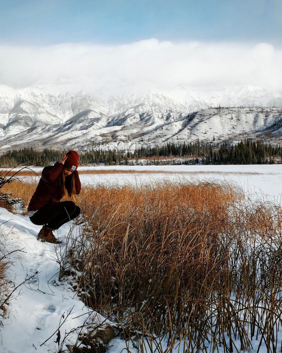 Free Image of Man Kneeling in Snow by Field 