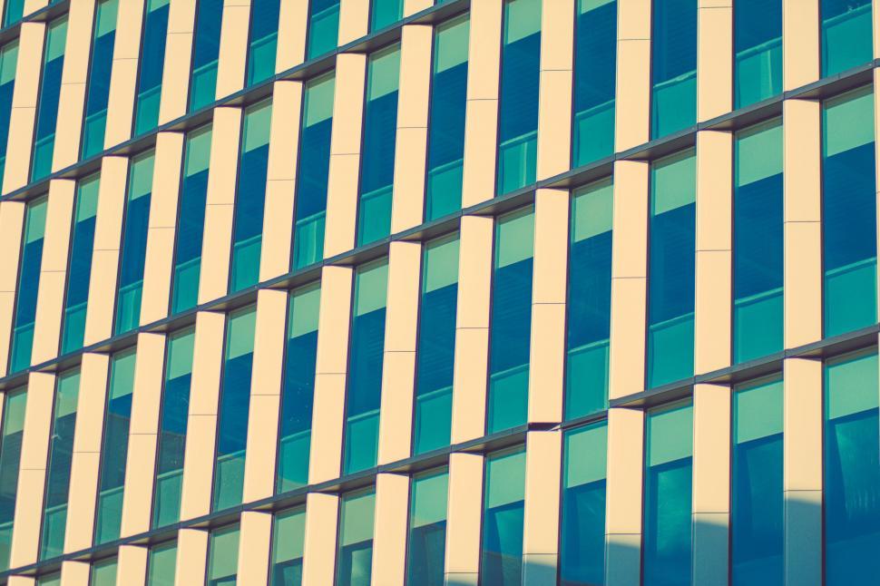Free Image of Tall Building With Lots of Windows Next to a Clock 