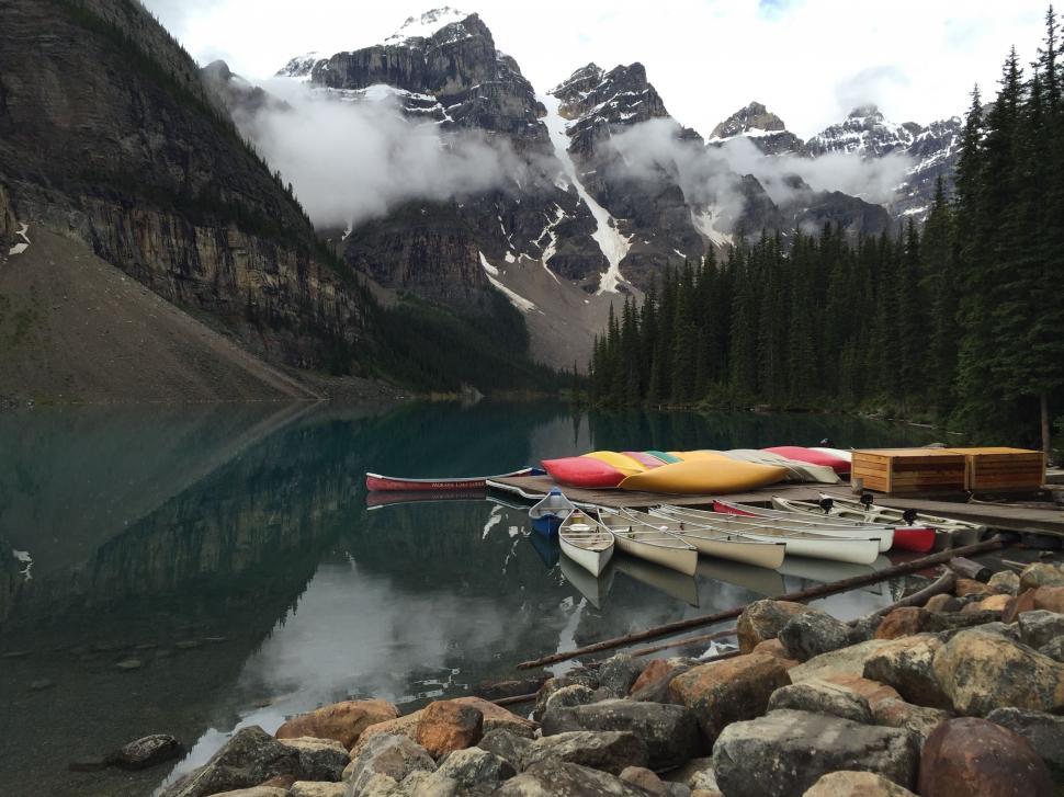 Free Image of Canoes Aligned on Shore of Mountain Lake 
