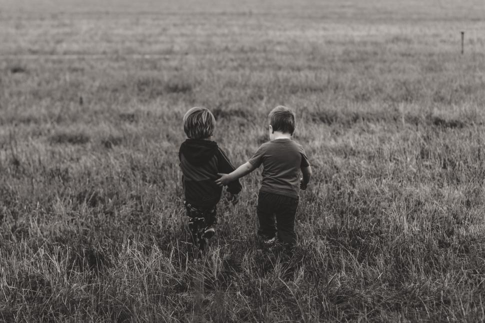 Free Image of Two Children Standing in the Grass 