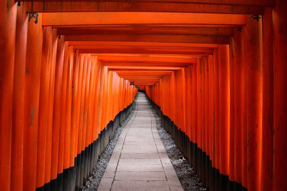 Free Image of Long Walkway Lined With Orange Gates Leading Into the Distance 
