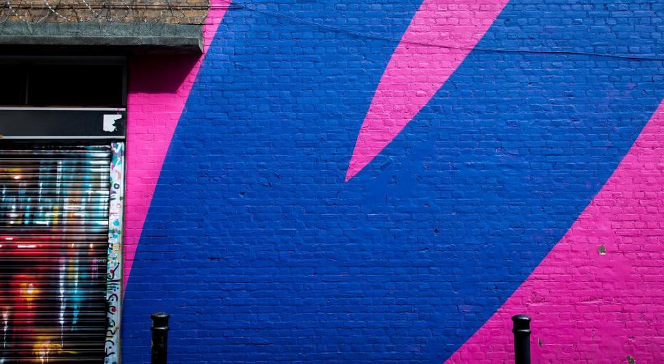 Free Image of Large Blue Bird Painted on Pink and Blue Wall 