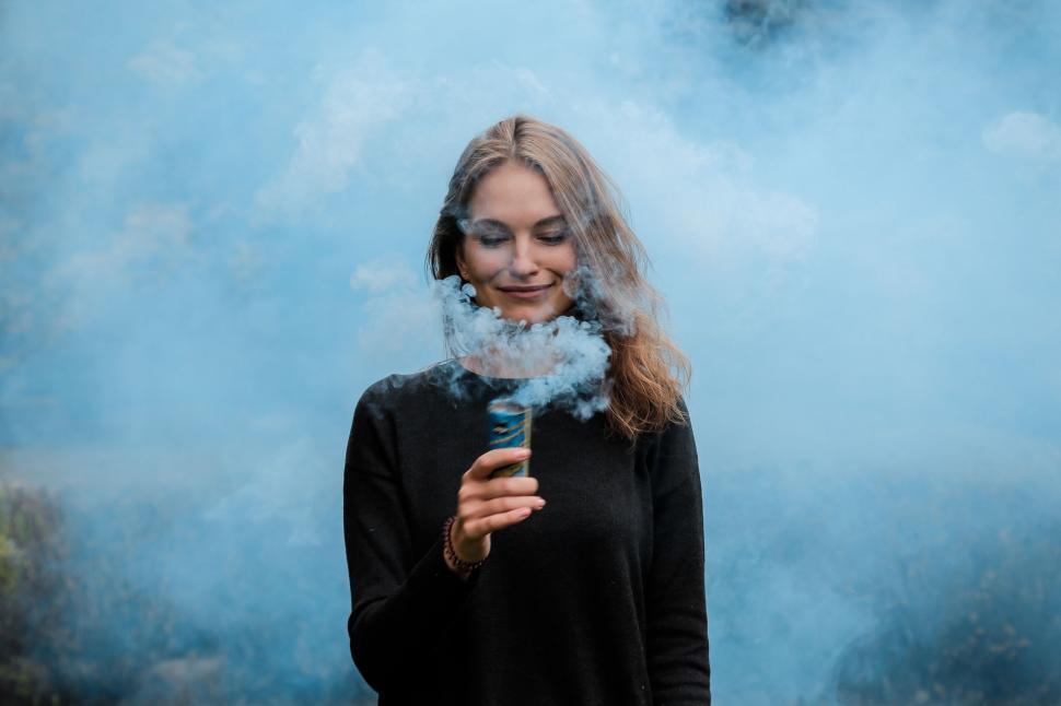 Free Image of Woman Standing in Front of Smoke Cloud 
