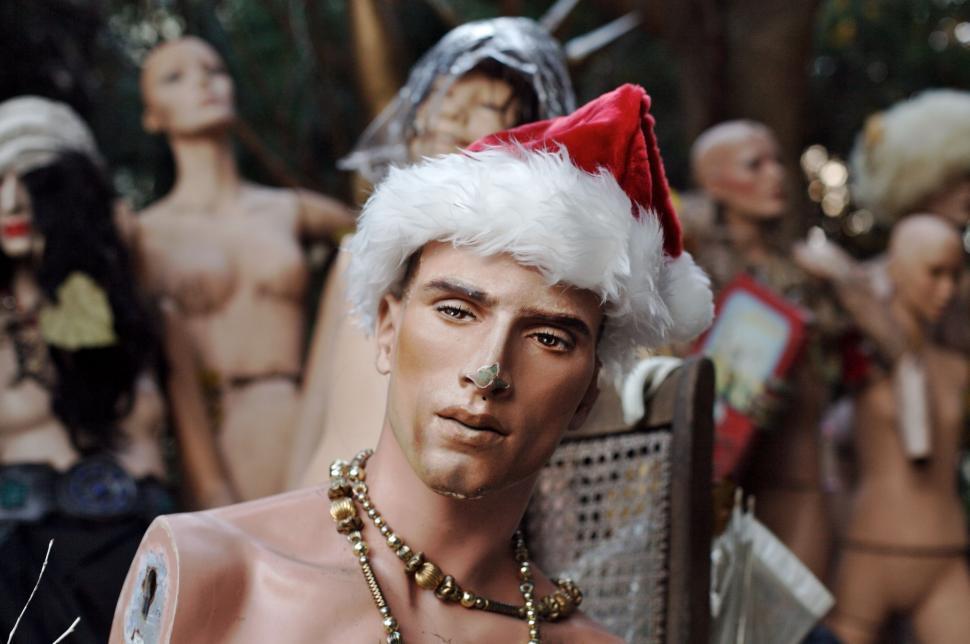 Free Image of Man in Santa Hat Standing in Front of Group of Naked Men 