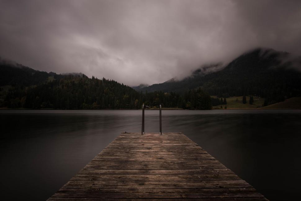 Free Image of Wooden Dock on Lake Under Cloudy Sky 