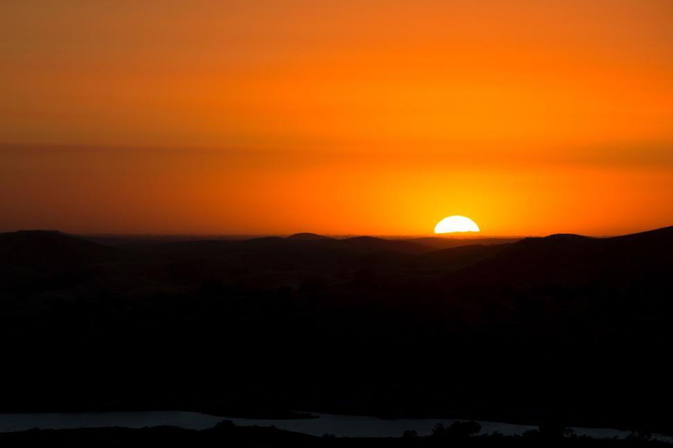Free Image of The Sun Setting Over a Mountain Range 
