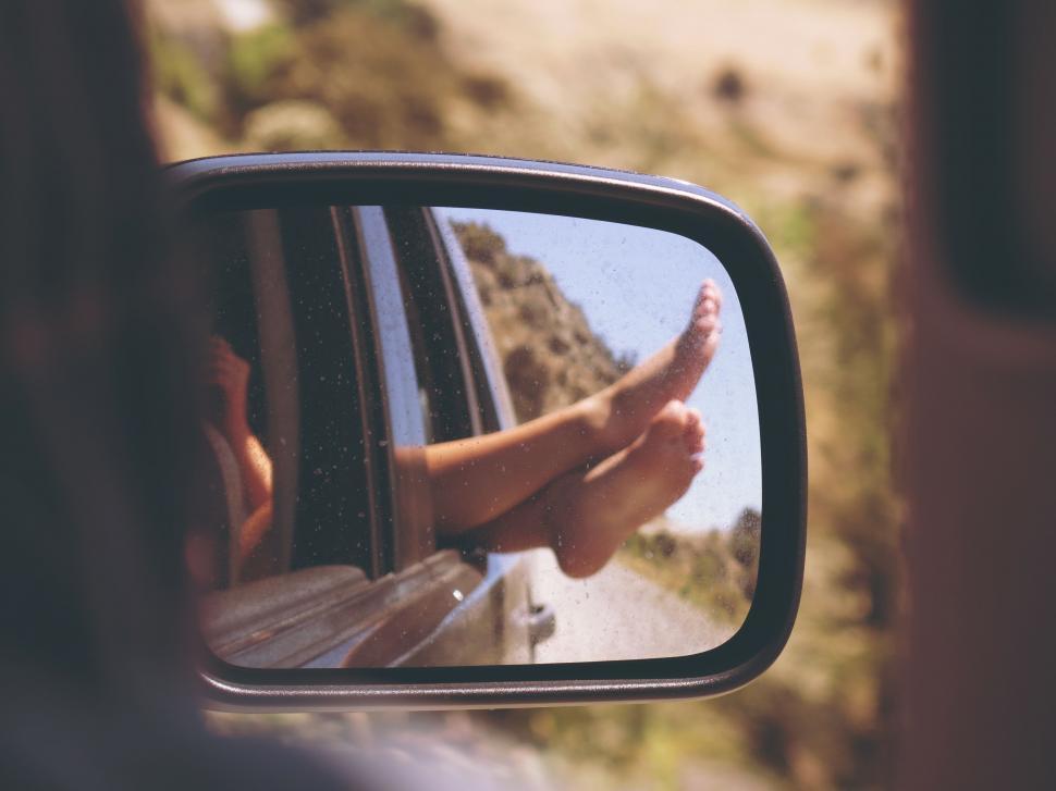Free Image of Persons Feet Sticking Out of Rear View Mirror 