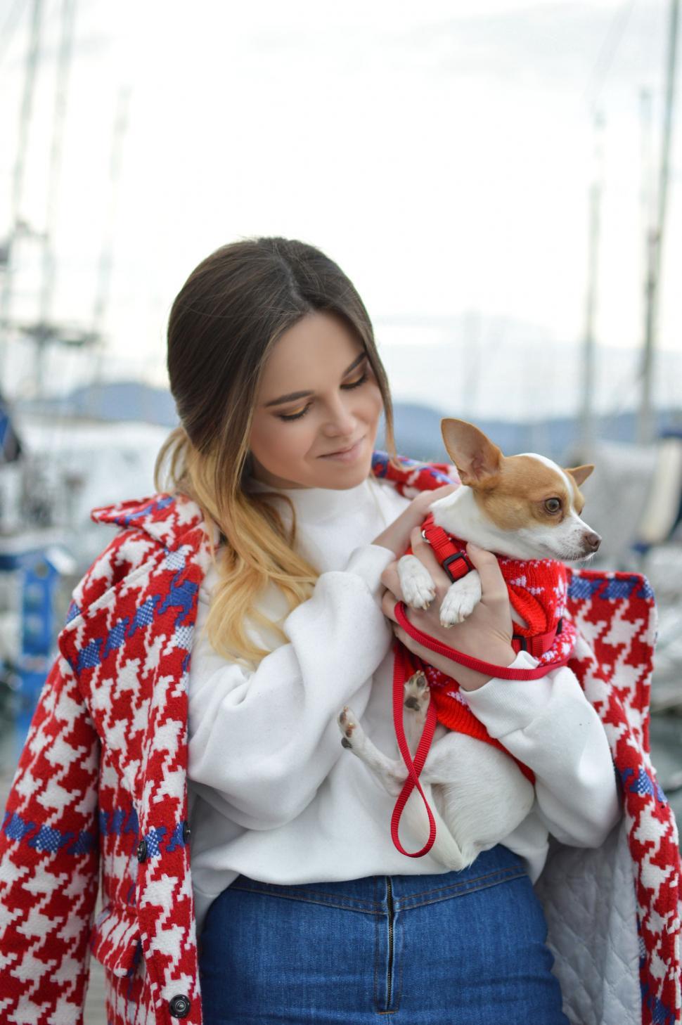 Free Image of Woman Holding Small Dog in Her Arms 