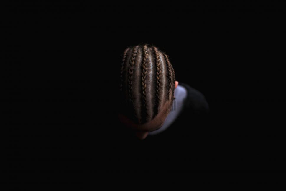 Free Image of Person With Braids Standing in the Dark 