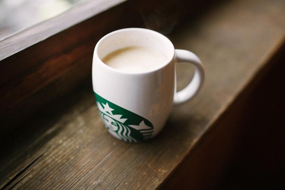 Free Image of Starbucks Cup Resting on Windowsill 