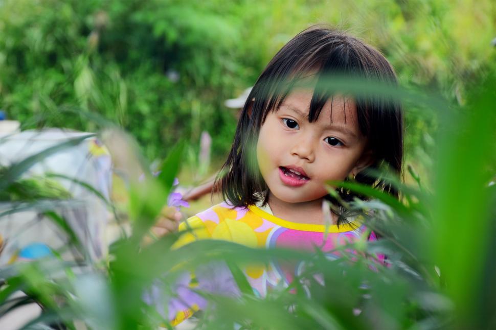 Free Image of Little Girl Sitting in a Field of Tall Grass 