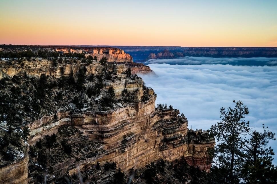 Free Image of Cliff Rising Above Sea of Clouds 