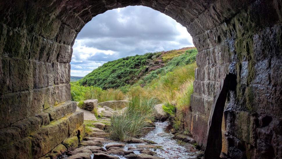 Free Image of Small Stream Flowing Through Stone Tunnel 