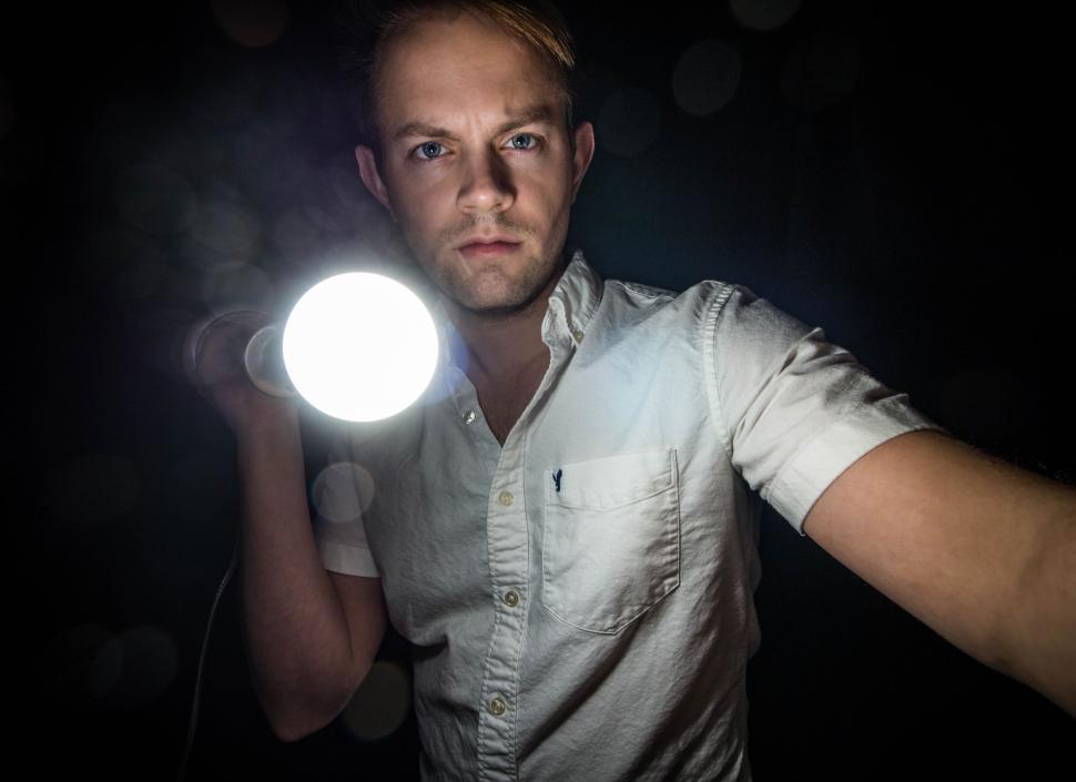 Free Image of Man Holding Light in Hand 
