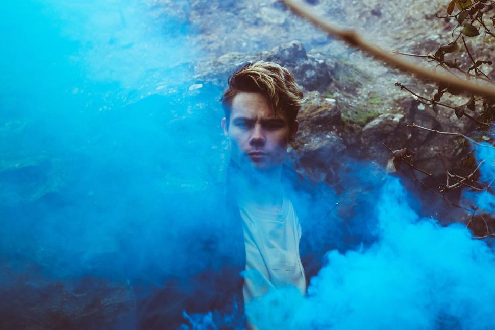 Free Image of Man Standing in Front of Blue Smoke 