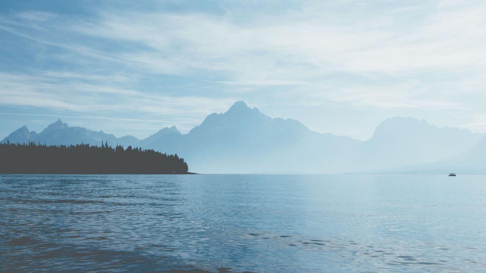 Free Image of Majestic Mountains Towering Over Vast Water 
