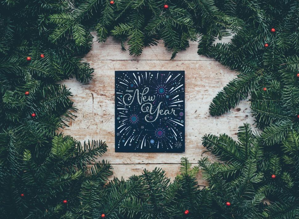 Free Image of A Christmas Card Surrounded by Evergreen Leaves 