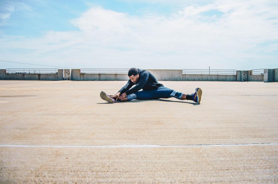 Free Image of Man Sitting on Ground With Skateboard 