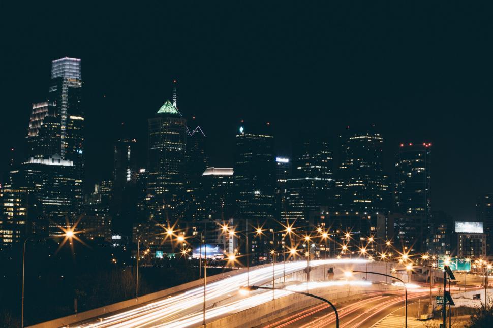 Free Image of City Skyline at Night With Cars Driving 