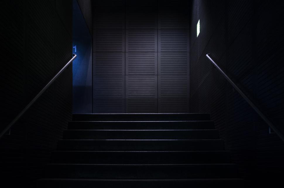 Free Image of Dark Hallway With Stairs Leading to Door 