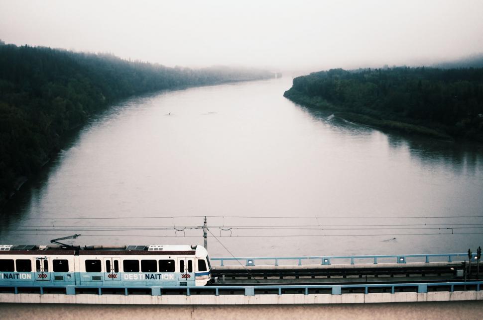 Free Image of Train Traveling Along River Tracks 