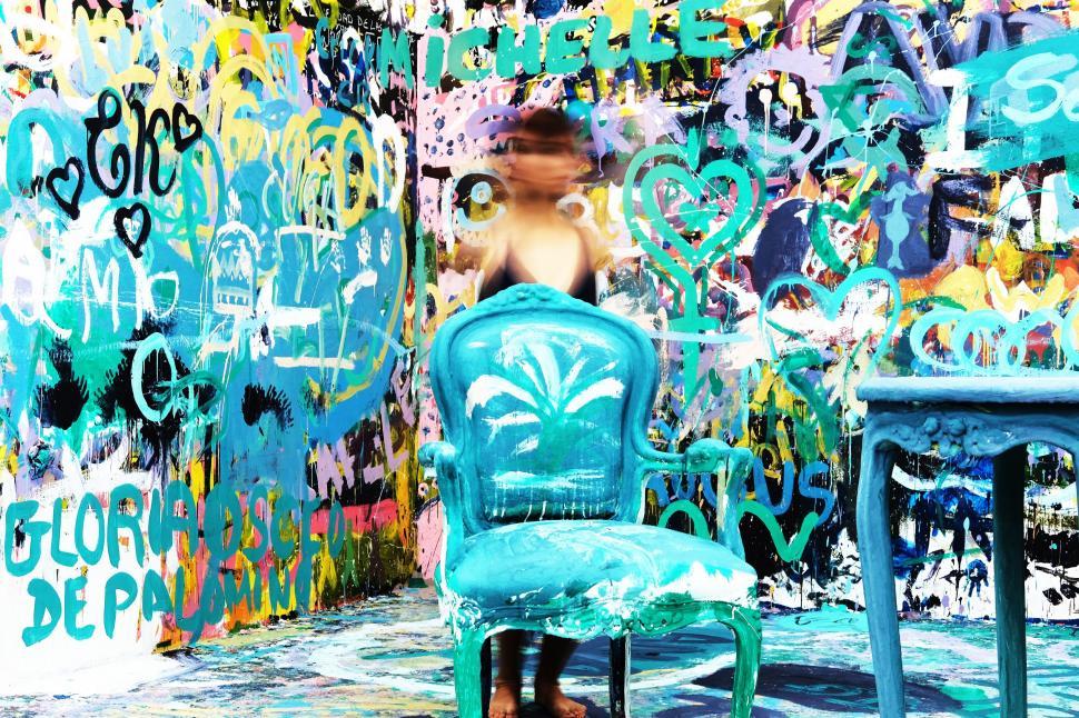 Free Image of Blue Chair in Front of Graffiti Wall 