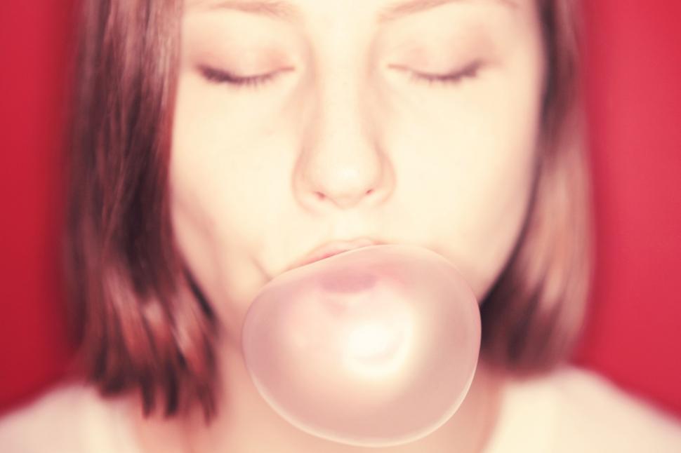 Free Image of Woman Blowing Bubble With Eyes Closed 