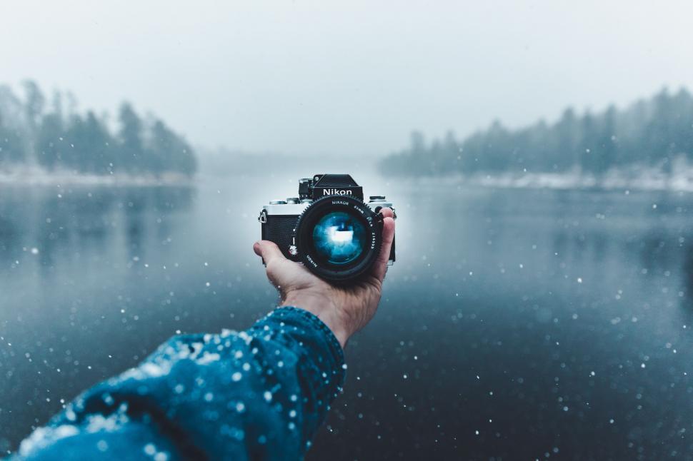 Free Image of Person Holding Camera by Body of Water 