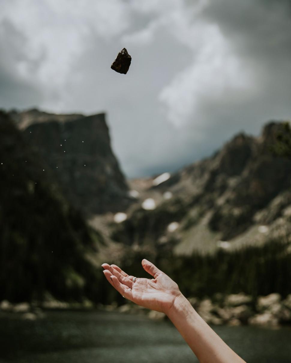 Free Image of Hand Reaching for Flying Object in the Sky 