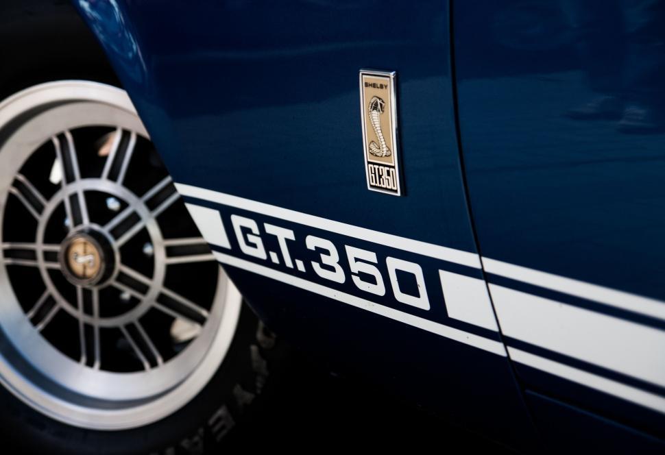 Free Image of Close Up of a Blue Car With White Stripes 