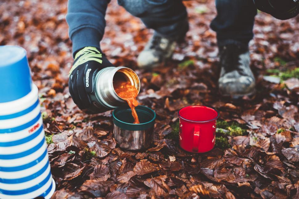 Free Image of Person Pouring Liquid Into Cup on Ground 