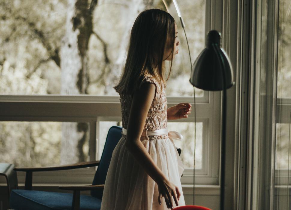Free Image of Little Girl Standing in Front of Window 